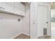Laundry room with white cabinets, washer and dryer hookups, and a door to the outside at 887 Lucas Ln, Oldsmar, FL 34677