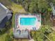 Aerial view of a clear blue community pool with lounge chairs and tables under the Florida sun at 887 Lucas Ln, Oldsmar, FL 34677