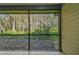Backyard view from the screened-in porch with tile flooring at 887 Lucas Ln, Oldsmar, FL 34677