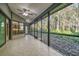 Spacious screened-in porch with tile flooring and a ceiling fan at 887 Lucas Ln, Oldsmar, FL 34677