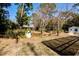 View of backyard with an ornamental well, a golf cart, an outbuilding, and mature trees at 8979 Hernando Way, Weeki Wachee, FL 34613
