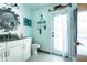 Bright bathroom features a white vanity, coastal accents, and access to the outdoors through a glass door at 8979 Hernando Way, Weeki Wachee, FL 34613