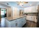 Kitchen features an island with granite countertop, wood floors, and modern appliances at 8979 Hernando Way, Weeki Wachee, FL 34613