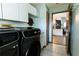 Laundry room with washer, dryer, and white storage cabinets at 8979 Hernando Way, Weeki Wachee, FL 34613