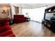 Bright living room with laminate floors, a plush sofa, and a modern entertainment center at 8979 Hernando Way, Weeki Wachee, FL 34613