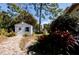 Image of the backyard outbuilding painted white with a blue shutter and a decorative blue star at 8979 Hernando Way, Weeki Wachee, FL 34613