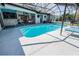 Spacious outdoor living area featuring a pool, shaded seating, and bar area for ultimate enjoyment at 8979 Hernando Way, Weeki Wachee, FL 34613