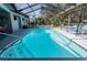 Stunning view of the sparkling pool surrounded by a screened enclosure and lush greenery at 8979 Hernando Way, Weeki Wachee, FL 34613