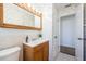 Bathroom features vanity with mirror, and patterned wallpaper with a view of the doorway at 10022 Lily N St # N, Pinellas Park, FL 33782
