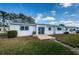 The home's exterior shows a sliding glass door, a well-maintained lawn and an air conditioning unit at 10022 Lily N St # N, Pinellas Park, FL 33782