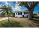Charming single-story home with a well-maintained lawn, palm tree, and white exterior with blue shutters at 10022 Lily N St # N, Pinellas Park, FL 33782