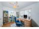 Bright home office features a ceiling fan, built-in shelving, light wood desk, and a comfortable blue office chair at 10022 Lily N St # N, Pinellas Park, FL 33782