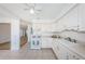 Open-concept kitchen with white cabinetry, tiled floors, and a view into the adjoining living space at 10022 Lily N St # N, Pinellas Park, FL 33782