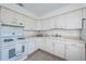 Functional kitchen featuring ample white cabinets, a gas stove, and neutral countertops at 10022 Lily N St # N, Pinellas Park, FL 33782