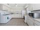 Well-lit kitchen with white appliances, ample cabinetry, and a tiled floor for easy maintenance at 10022 Lily N St # N, Pinellas Park, FL 33782