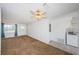 Inviting living room featuring carpet floors, a ceiling fan, and a large window for plenty of natural light at 10022 Lily N St # N, Pinellas Park, FL 33782