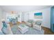 Bright living room with coastal-themed decor, including white wicker furniture and a matching blue area rug at 10022 Lily N St # N, Pinellas Park, FL 33782