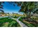 Scenic pond view with a fountain, park benches, lush trees and manicured landscaping at 10022 Lily N St # N, Pinellas Park, FL 33782