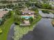 A bird's eye view of a community pool, clubhouse, and pond with dock at 10263 Gandy N Blvd # 209, St Petersburg, FL 33702