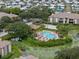 Aerial view of a community swimming pool surrounded by palm trees and lush greenery at 10263 Gandy N Blvd # 209, St Petersburg, FL 33702