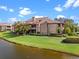 Exterior view of community condos with lawns, mature landscaping and water view at 10263 Gandy N Blvd # 209, St Petersburg, FL 33702