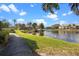 Scenic view of community lake with dock, lush landscaping, and inviting walking path at 10263 Gandy N Blvd # 209, St Petersburg, FL 33702