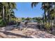 Relaxing lakeside patio area with lounge chairs and a table surrounded by palm trees at 10263 Gandy N Blvd # 209, St Petersburg, FL 33702