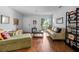 Cozy living area featuring wood floors, comfortable seating, and a sliding door to a balcony with outdoor views at 10263 Gandy N Blvd # 209, St Petersburg, FL 33702