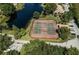 Aerial view of two well-maintained tennis courts surrounded by trees and a pond at 10263 Gandy N Blvd # 209, St Petersburg, FL 33702
