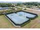 Aerial shot of a community tennis court surrounded by manicured landscaping and lush greenery at 11008 Tahiti Isle Ln, Tampa, FL 33647