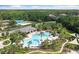 Overhead view of a community pool, tennis court, and playground surrounded by verdant landscapes at 11008 Tahiti Isle Ln, Tampa, FL 33647