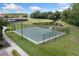 Outdoor basketball court with fences, manicured grass, and a serene pond offers an active lifestyle at 11008 Tahiti Isle Ln, Tampa, FL 33647
