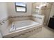 Modern bathroom with soaking tub featuring mosaic tile surround at 11008 Tahiti Isle Ln, Tampa, FL 33647