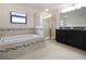A well-lit bathroom featuring a soaking tub and glass-enclosed shower at 11008 Tahiti Isle Ln, Tampa, FL 33647