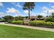Beautifully landscaped Beach Club entrance with lush greenery, colorful flowers, and a clear blue sky at 11008 Tahiti Isle Ln, Tampa, FL 33647