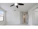 A bright, carpeted bedroom features a ceiling fan, large window, and doorways at 11008 Tahiti Isle Ln, Tampa, FL 33647