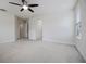 A large, carpeted bedroom featuring a ceiling fan, large window, and doorways at 11008 Tahiti Isle Ln, Tampa, FL 33647