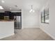 Bright dining area featuring a modern chandelier, large window, and tile flooring next to a stainless steel refrigerator at 11008 Tahiti Isle Ln, Tampa, FL 33647