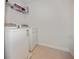 Convenient laundry room featuring a washer, dryer and overhead storage at 11008 Tahiti Isle Ln, Tampa, FL 33647
