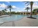 Inviting community pool area surrounded by palm trees, lounge chairs, and a covered pavilion at 11008 Tahiti Isle Ln, Tampa, FL 33647