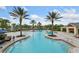 Large community pool featuring multiple seating areas, mature landscaping, and a splash fountain at 11008 Tahiti Isle Ln, Tampa, FL 33647