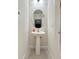 Small powder room features a pedestal sink and oval mirror, a space-saving design at 11008 Tahiti Isle Ln, Tampa, FL 33647