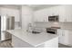 Modern kitchen features stainless appliances, white cabinetry, quartz countertops, and an island with a sink at 12150 Cattleside Dr, Riverview, FL 33579