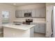 Modern kitchen with a center island, gray cabinets, stainless appliances, and bright countertop at 13008 Wellspring Dr, Lithia, FL 33547