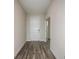 Inviting hallway with wood-look floors leading to a white front door and linen closet at 14441 Meadow Bird Ave, Riverview, FL 33579