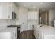 Well-lit kitchen showcasing white cabinets, stainless steel appliances, and a functional layout with wood-look floors at 14441 Meadow Bird Ave, Riverview, FL 33579
