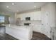 White kitchen featuring stainless steel appliances, island with sink and open layout to adjacent room at 14441 Meadow Bird Ave, Riverview, FL 33579