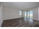 Spacious living room featuring wood-look floors, a large window, and sliding glass doors to patio at 14441 Meadow Bird Ave, Riverview, FL 33579