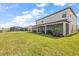 Spacious backyard featuring a covered patio and manicured landscaping is enhanced by scenic views of a nearby lake at 15315 Golden Beam Pl, Bradenton, FL 34211