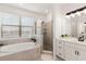Bright bathroom showcasing a soaking tub, separate shower, and dual vanity with modern fixtures at 15315 Golden Beam Pl, Bradenton, FL 34211